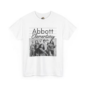 May include: White t-shirt with a black and white image of the cast of "Abbott Elementary." The words "Abbott Elementary" are printed above the image in a black, stylised font.