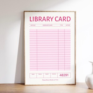 Puede incluir: Una impresi&oacute;n enmarcada con un dise&ntilde;o de tarjeta de biblioteca rosa. Las palabras "LIBRARY CARD" est&aacute;n en la parte superior, con campos para "DATE DUE", "BORROWER'S NAME", "TITLE" y "AUTHOR". La parte inferior incluye "Genre", "Format", "Branch" y "Librarian".