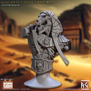 Może przedstawiać: Szczegółowe, szare popiersie szkieletowej istoty z psim czaszką, ozdobione nakryciem głowy i skomplikowaną zbroją. Część kolekcji popiersi kolekcjonerskich "Guul'Rath + Dune TombLord". Podstawa jest jasnoszara.