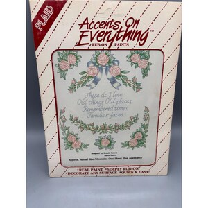 Puede incluir: Un paquete de pinturas de frotar "Accents On Everything". El diseño presenta rosas rosas, lazos azules y el texto "These do I love: Old things Old places Remembered times Familiar faces." El paquete es blanco con rayas diagonales rojas y blancas.