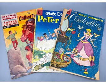 May include: Three vintage comic books featuring illustrated covers. The left shows Classics Illustrated Junior No. 523 The Gallant Tailor. The center is a Dell Walt Disney Peter Pan. The right is a Walt Disney Cinderella comic book.