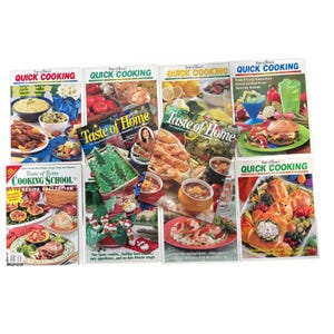 May include: A collection of eight cookbooks titled "Quick Cooking" and "Taste of Home." The covers feature images of various dishes, including salads, burgers, and seafood. The cookbooks are arranged on a white surface.