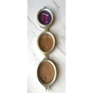 May include: A vertical arrangement of three connected oval photo frames with a metallic silver finish. The top frame contains a purple insert with the text Link Ups Photo Frames That Link To Each Other. The lower two frames have brown backings.