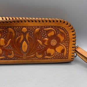Cartera vintage de piel repujada color canela, hecha a mano, con cremallera y correa de muñeca con diseño floral