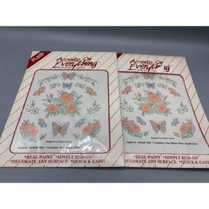 Puede incluir: Dos paquetes de transferencias de pintura frotada con diseños florales y de mariposas. Los paquetes llevan la etiqueta "Accents On Everything" y "Real Paint, Simply Rub-On, Decorate Any Surface, Quick & Easy!"
