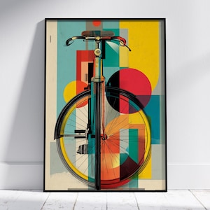 May include: A framed art print of a stylized bicycle illustration. The artwork depicts a bicycle with a black frame, yellow wheel, and colourful geometric shapes in red, yellow, blue, and orange. The print is set against a light background.