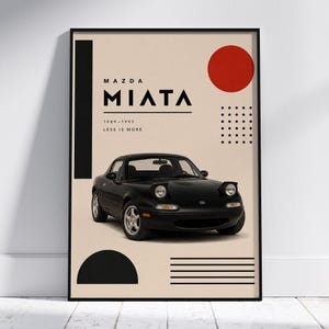 Könnte beinhalten: Schwarzes Mazda Miata Auto-Poster mit dem Text "MAZDA MIATA 1989-1997 LESS IS MORE" in einem schwarzen Rahmen. Das Poster hat einen beigefarbenen Hintergrund mit schwarzen geometrischen Formen und einem roten Kreis.