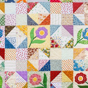 May include: A colorful patchwork quilt with a floral design. The quilt is made up of squares and triangles of different fabrics, each with a unique pattern. The quilt features a variety of colors, including red, blue, green, yellow, and purple. The quilt is decorated with appliqued flowers in the center of each square.