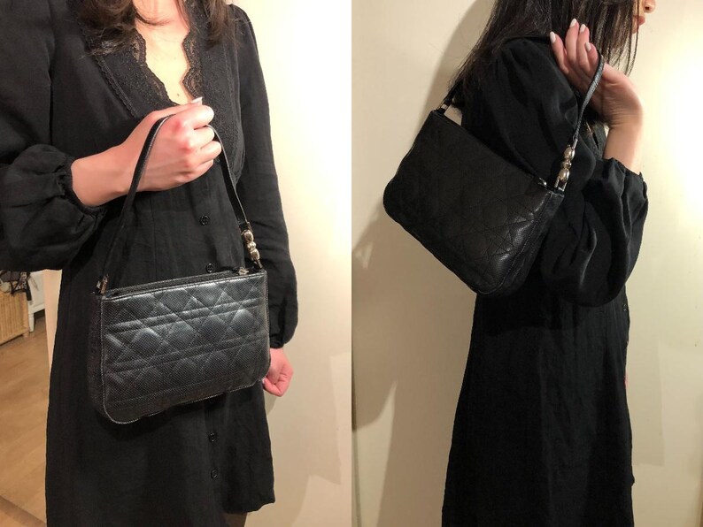 May include: A black quilted leather handbag with a silver chain strap. The bag has a flap closure and a small, rectangular shape.