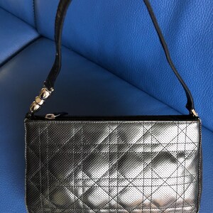 May include: A black quilted leather handbag with a silver zipper and a silver chain strap.