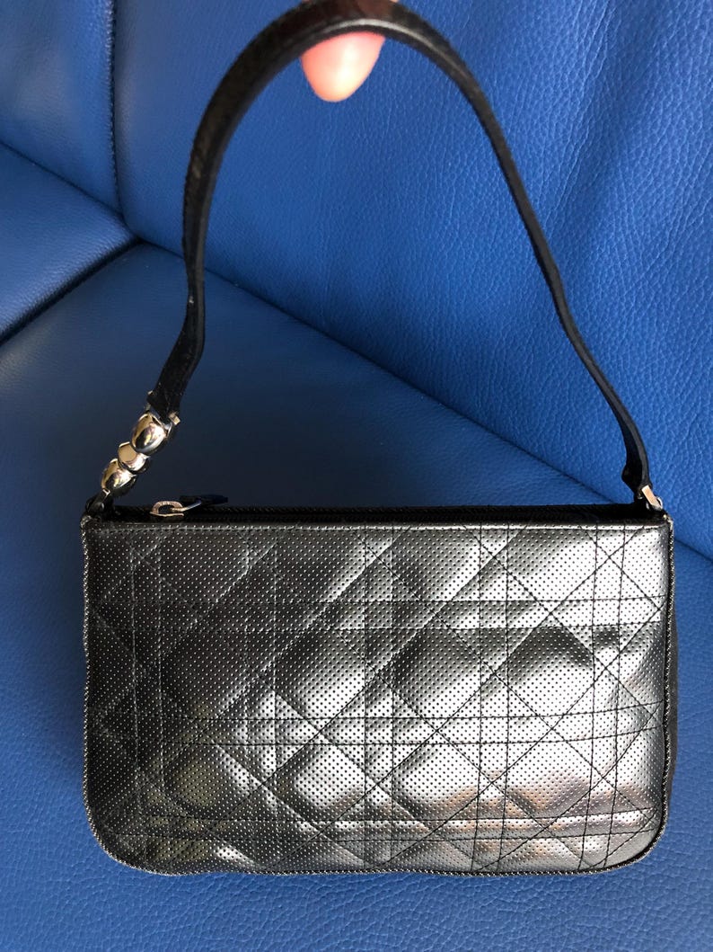 May include: A black quilted leather handbag with a silver zipper and a silver chain strap.