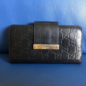 Cartera Gucci de piel negra con monograma