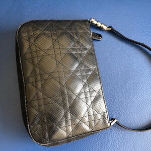 May include: Black quilted leather shoulder bag with a silver chain strap and a silver clasp.