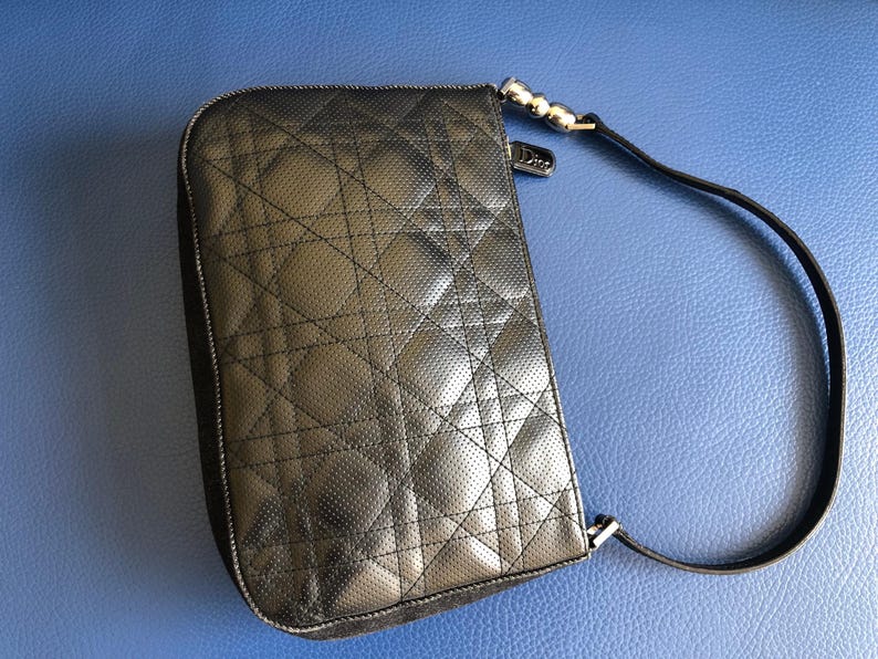 May include: Black quilted leather shoulder bag with a silver chain strap and a silver clasp.
