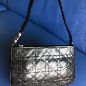 May include: A black quilted leather handbag with a silver chain strap and a zipper closure.