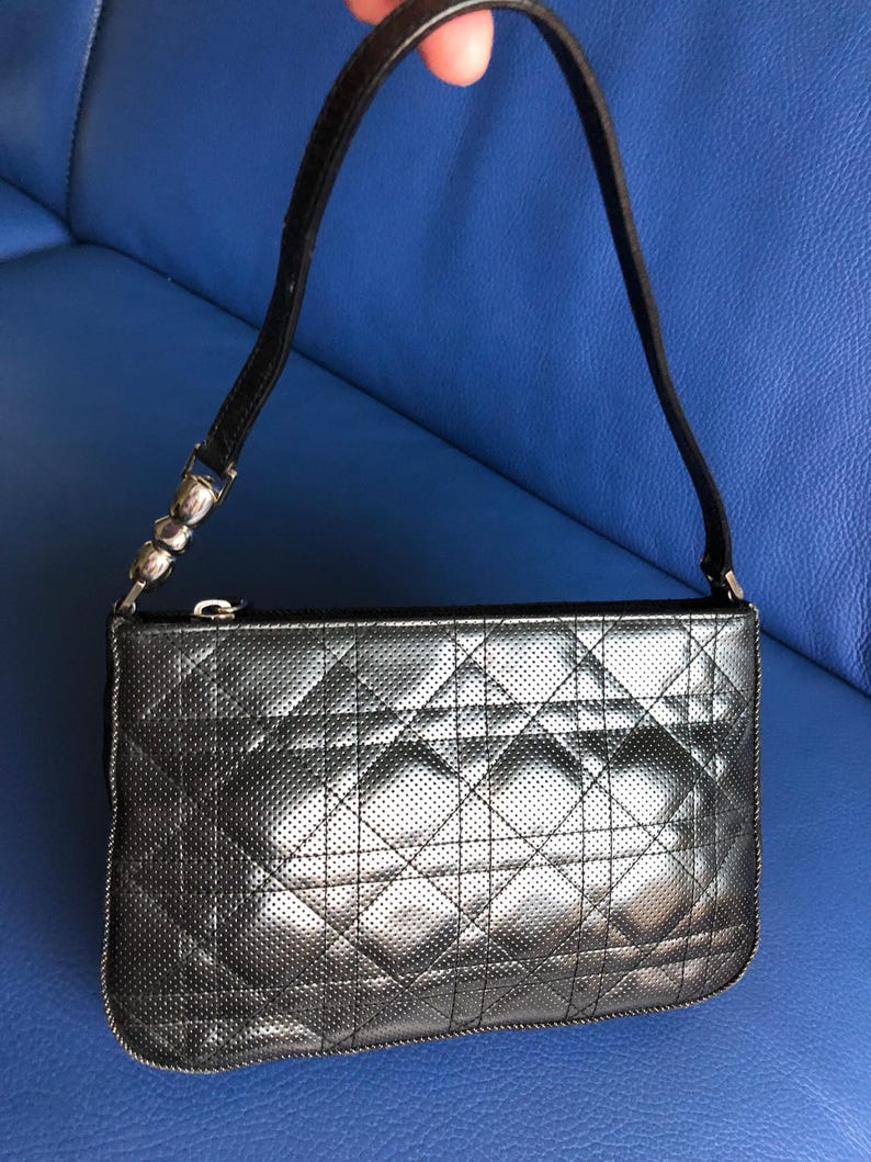 May include: A black quilted leather handbag with a silver chain strap and a zipper closure.