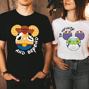 May include: Two t-shirts with a cartoon design. The black t-shirt has a cartoon image of Woody from Toy Story with the text "And Beyond". The white t-shirt has a cartoon image of Buzz Lightyear from Toy Story with the text "To Infinity".