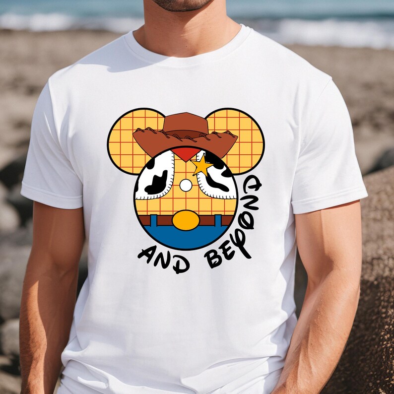 May include: White t-shirt with a cartoon image of Woody from Toy Story in a Mickey Mouse silhouette. The text "And Beyond" is written below the image.