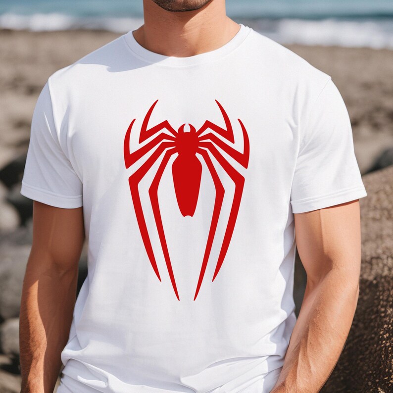 May include: White t-shirt with a red spider-man logo printed on the front.