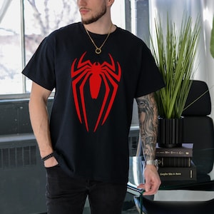 May include: A black t-shirt with a red spider-man logo on the front.
