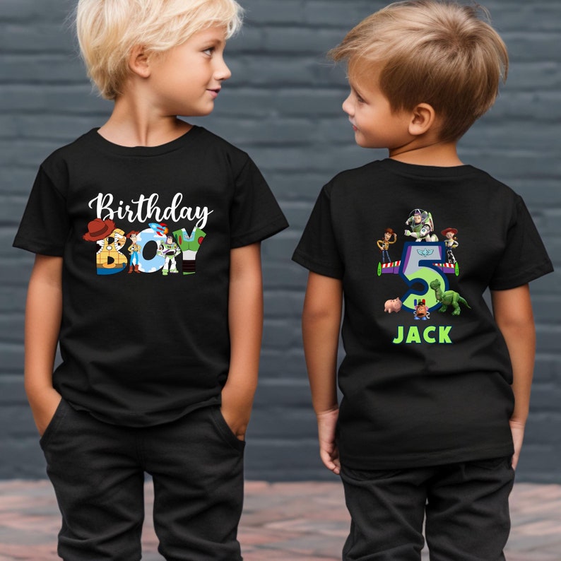 May include: Two black t-shirts with a Toy Story theme. The front shirt says "Birthday Boy" with characters from the movie forming the letters. The back shirt has a number "5" with Toy Story characters around it and the name "Jack" underneath.