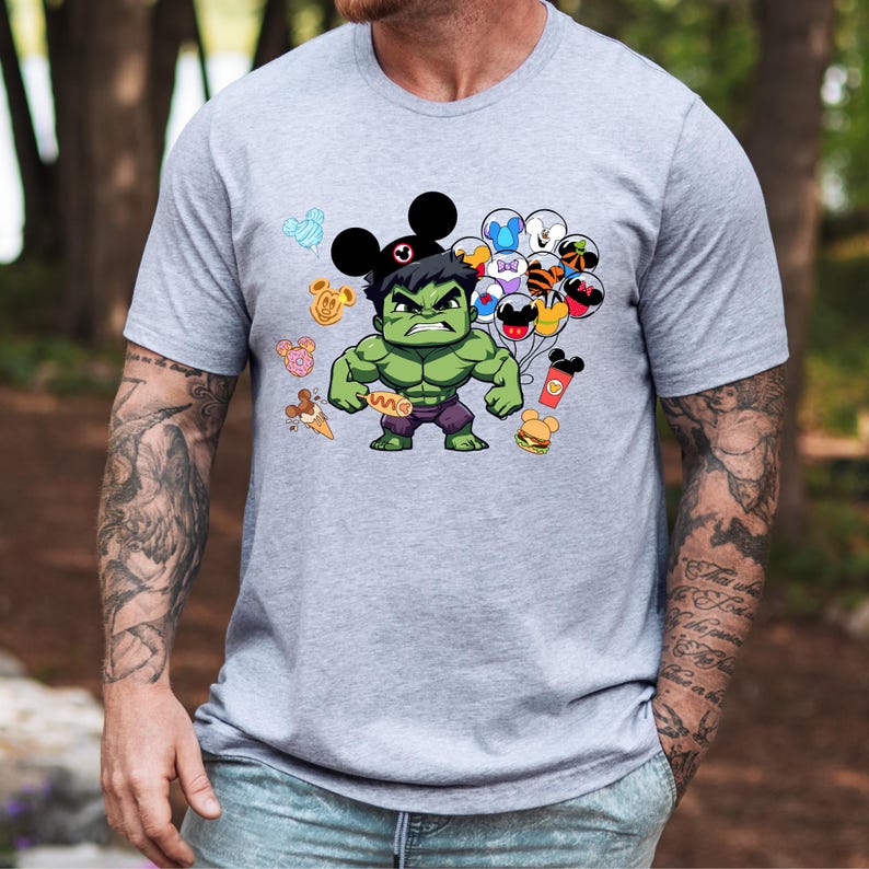 Puede incluir: Una camiseta gris con un Hulk de dibujos animados verde que lleva un sombrero de Mickey Mouse y sostiene globos con varios personajes de Disney. El texto "Save" est&aacute; impreso en la camiseta de Hulk.