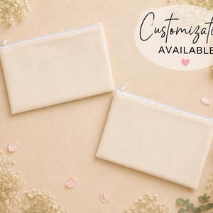 May include: Two rectangular, cream-colored zippered pouches with a smooth, solid-colored surface. A white oval graphic in the upper right corner contains the black text Customization AVAILABLE with a small pink heart icon below the text.
