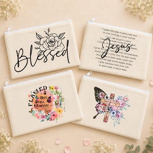 May include: Four rectangular off-white canvas zipper pouches. One features a black rose and the word Blessed. One has text about Jesus. One displays a floral wreath with butterflies and the text Flawed But Still Worthy. One shows a cross and flowers.