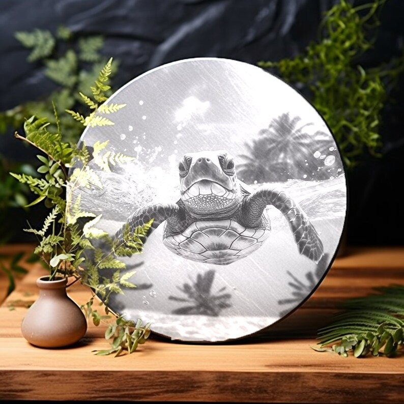 May include: A black and white image of a sea turtle swimming in the ocean. The turtle is facing the camera and has its mouth open. The image is on a round, white background.