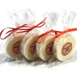 May include: Three round bars of orange chili pepper soap wrapped individually in clear plastic bags tied with orange ribbon. The soap is labeled "The Concord Soap Company" and "Orange Chili Pepper".