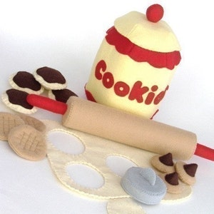 Peut inclure: Ensemble de nourriture en feutre pour jouer à faire semblant. Comprend un pot à biscuits, un rouleau à pâtisserie, de la pâte à biscuits et des biscuits. Le pot à biscuits est jaune avec des garnitures rouges et dit "Cookies".