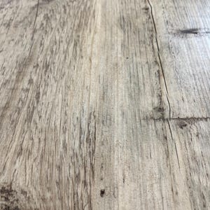 May include: Close-up of a light brown wooden surface with a knot and grain patterns.