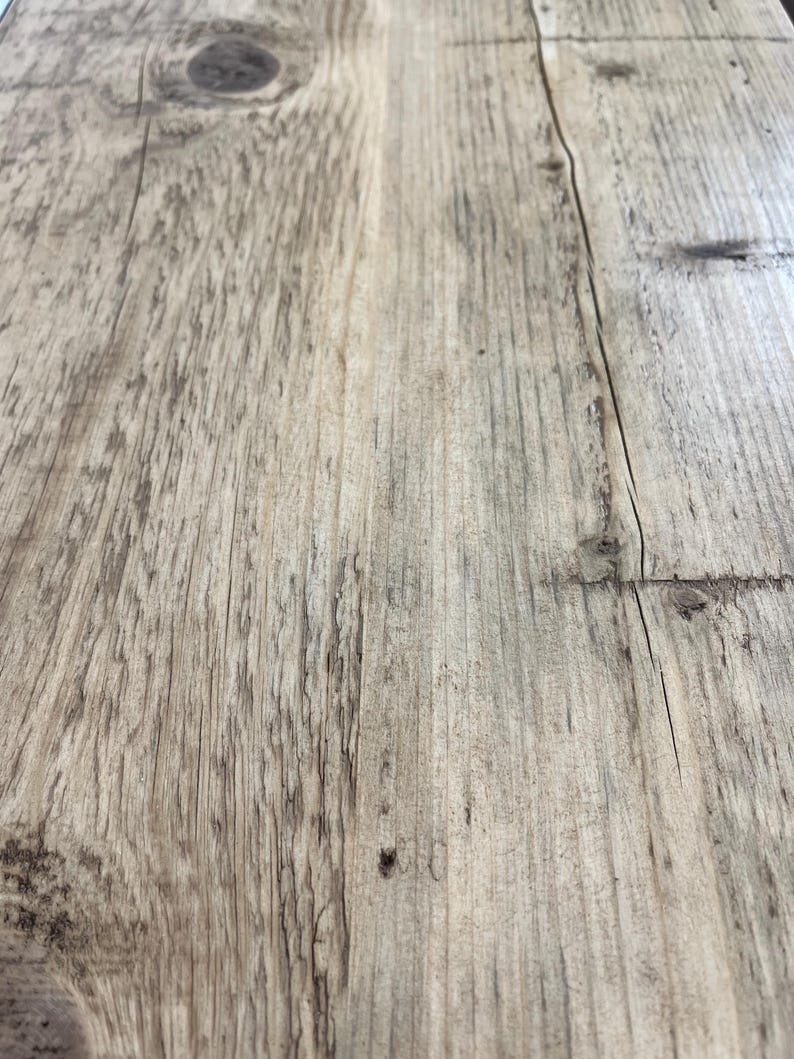 May include: Close-up of a light brown wooden surface with a knot and grain patterns.