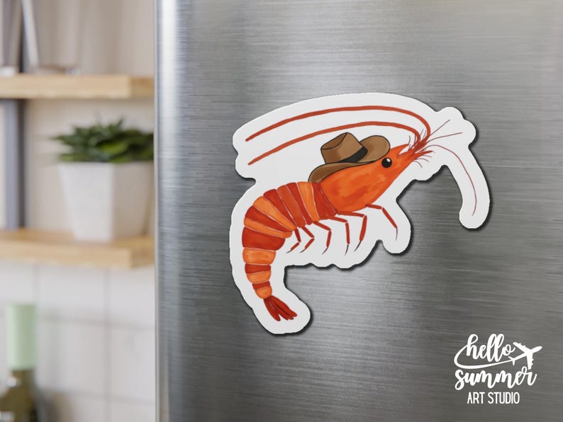 May include: A red shrimp wearing a brown cowboy hat. The shrimp is on a white background with the text "hello summer art studio" in black.