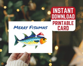 Op de afbeelding: Een afdrukbare kerstkaart met een aquarel illustratie van een vis met een kerstmuts. De kaart leest "Merry Fishmas" in blauw schrift. Een rode vierkant met witte tekst leest "Direct downloaden Printbare kaart".