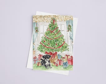 Pode incluir: Cartão de Natal em aquarela com uma árvore decorada com fitas e enfeites vermelhos, rodeada de presentes embrulhados. Um filhote preto e branco está sentado em frente à árvore. O cartão está em um fundo branco.