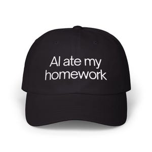 May include: Black baseball cap featuring the white embroidered text "AI ate my homework". The cap has a curved peak and a traditional six-panel construction. A casual accessory for everyday wear.