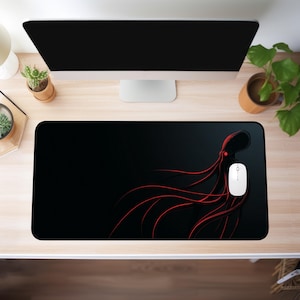 May include: Black rectangular mousepad featuring a red octopus design. The octopus illustration has long, flowing tentacles. A white computer mouse is on the right side of the mousepad. The mousepad is on a light wood desk.