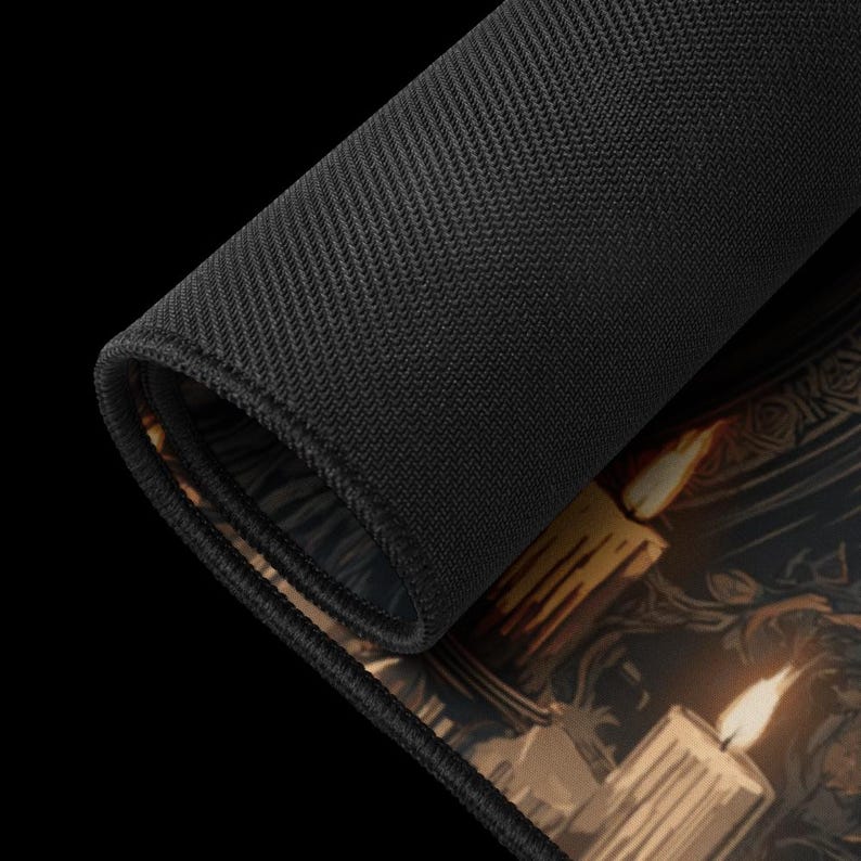 K&ouml;nnte beinhalten: Aufgerollte schwarze Mausunterlage mit einer detaillierten Illustration von brennenden Kerzen und kunstvollen Designs. Die Mausunterlage hat eine schwarze, strukturierte Oberfl&auml;che auf der R&uuml;ckseite und eine glatte, bedruckte Oberfl&auml;che auf der Vorderseite.