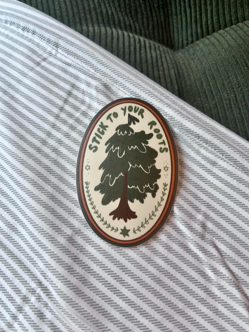 May include: A round sticker with a green tree and the text "Stick to your roots" in a white circle with a brown border.