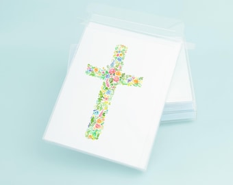 May include: A stack of blank white cards with a floral cross design printed on the top card. The cards are packaged in a clear plastic sleeve.