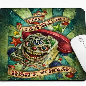 May include: A rectangular mousepad with a colorful, cartoonish design featuring a grinning, clown-like telephone. The text "THE CALL IS COMING FROM INSIDE THE HOUSE" is displayed on banners. A white wireless mouse is next to the mousepad.