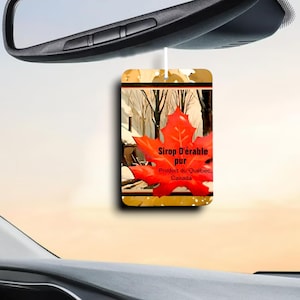 May include: A red maple leaf with the text "Sirop D'érable pur Produit du Québec, Canada" on a car air freshener. The background is a watercolor painting of a snowy forest scene.