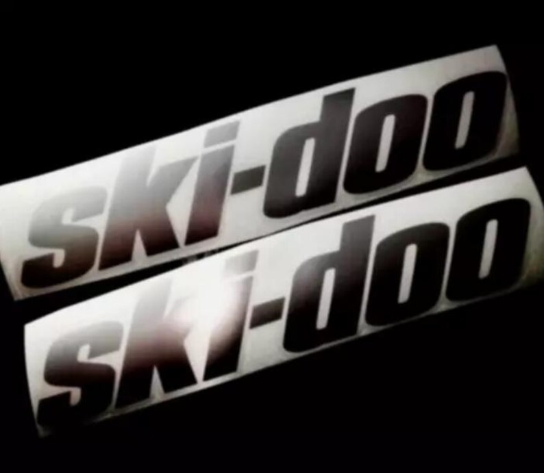 May include: Two black and white vinyl decals with the text "Ski-Doo" in a bold, stylized font.
