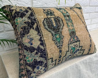 Peut inclure: Coussin rectangulaire beige avec un motif de tapis vintage. Le coussin présente un panneau central beige avec des rayures verticales et des motifs ornés en turquoise, marine et rose. Les extrémités ont un motif bleu marine et floral.