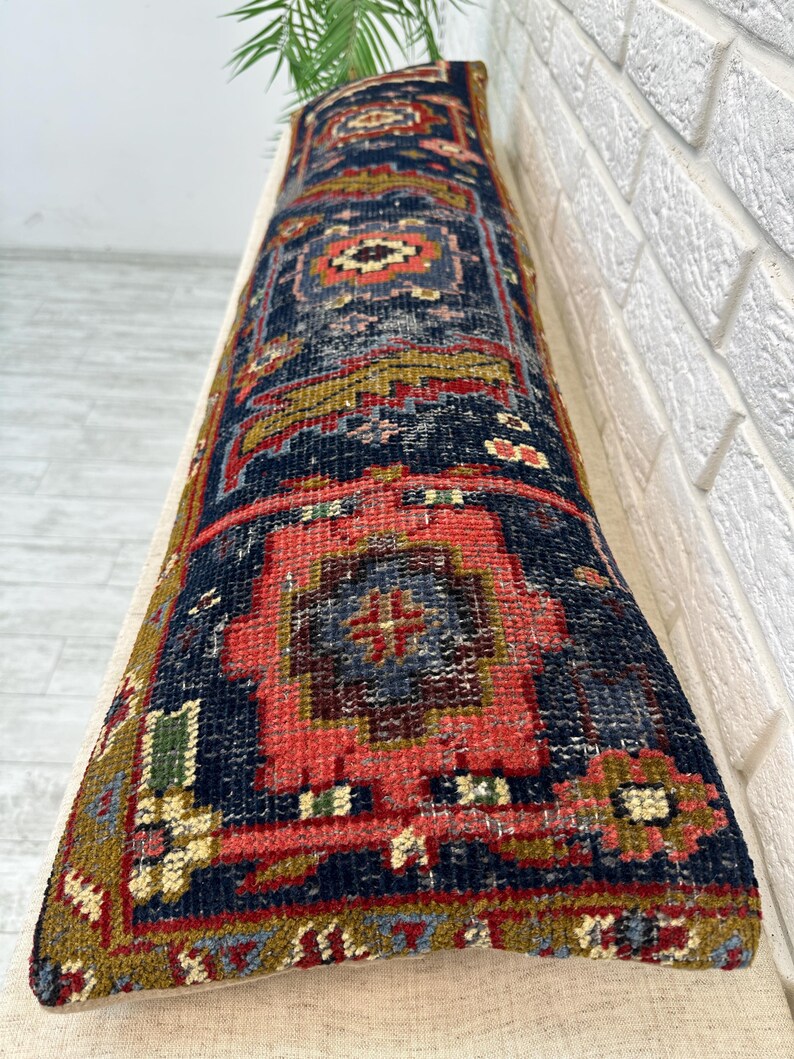 May include: A long, rectangular rug with a detailed, geometric pattern. The rug features a navy blue background with red, gold, and green accents. The design includes central medallions and borders, creating a traditional, vintage aesthetic.