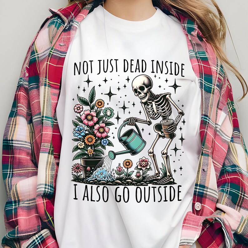 Pode incluir: Camiseta branca com um esqueleto regando flores e o texto "Not just dead inside I also go outside".