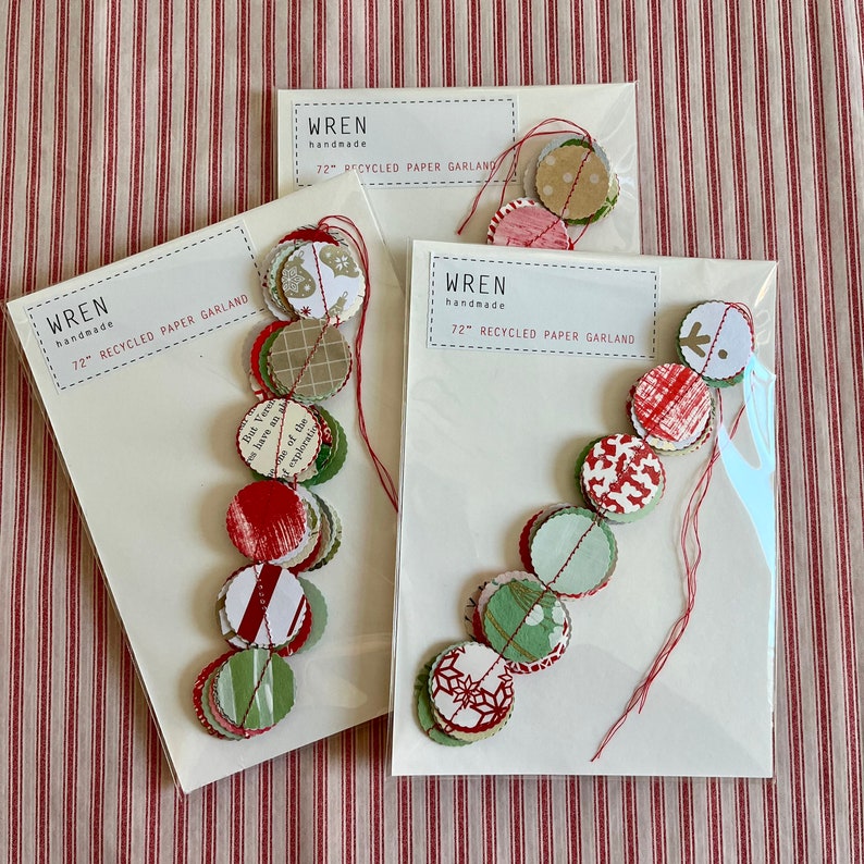 May include: Three 72-inch recycled paper garlands with red and green paper circles. The garlands are handmade by Wren.