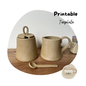 May include: Printable template for a ceramic creamer and sugar bowl set. The set is beige and has a rustic, handmade look. The template includes a spoon.