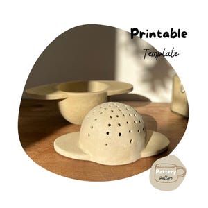 May include: Printable template for a ceramic tea infuser with a round, perforated body and a flat, curved base. The template is beige and has the text "Pottery Pattern" on a small mug icon.